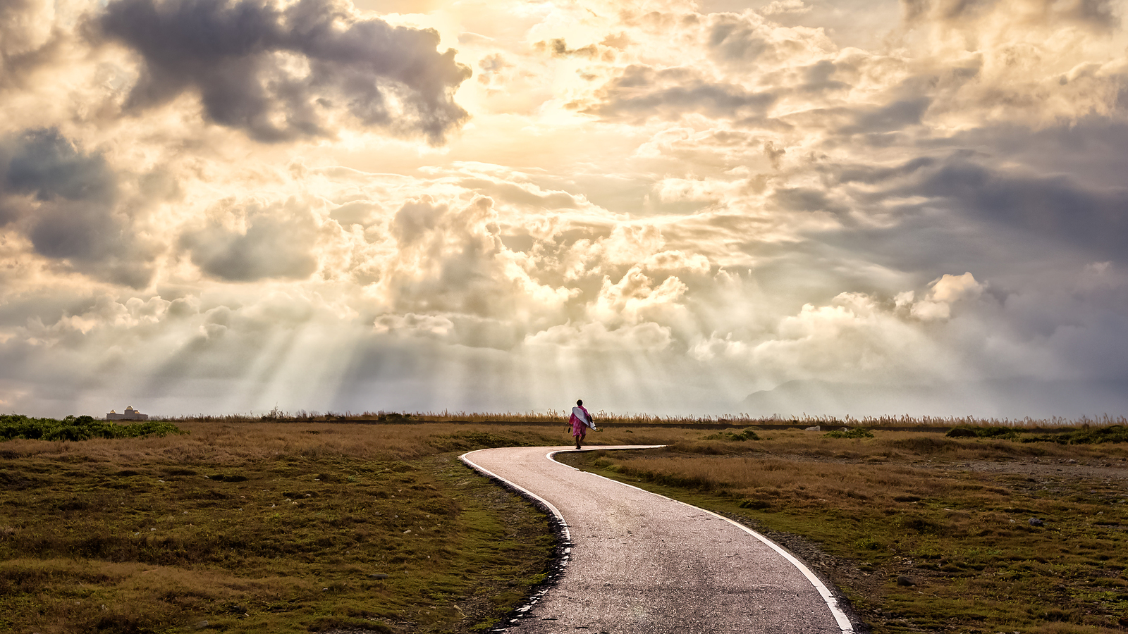 Sun's rays are shining down on a person walking along a winding path, calm and confident after counseling in the Portland area