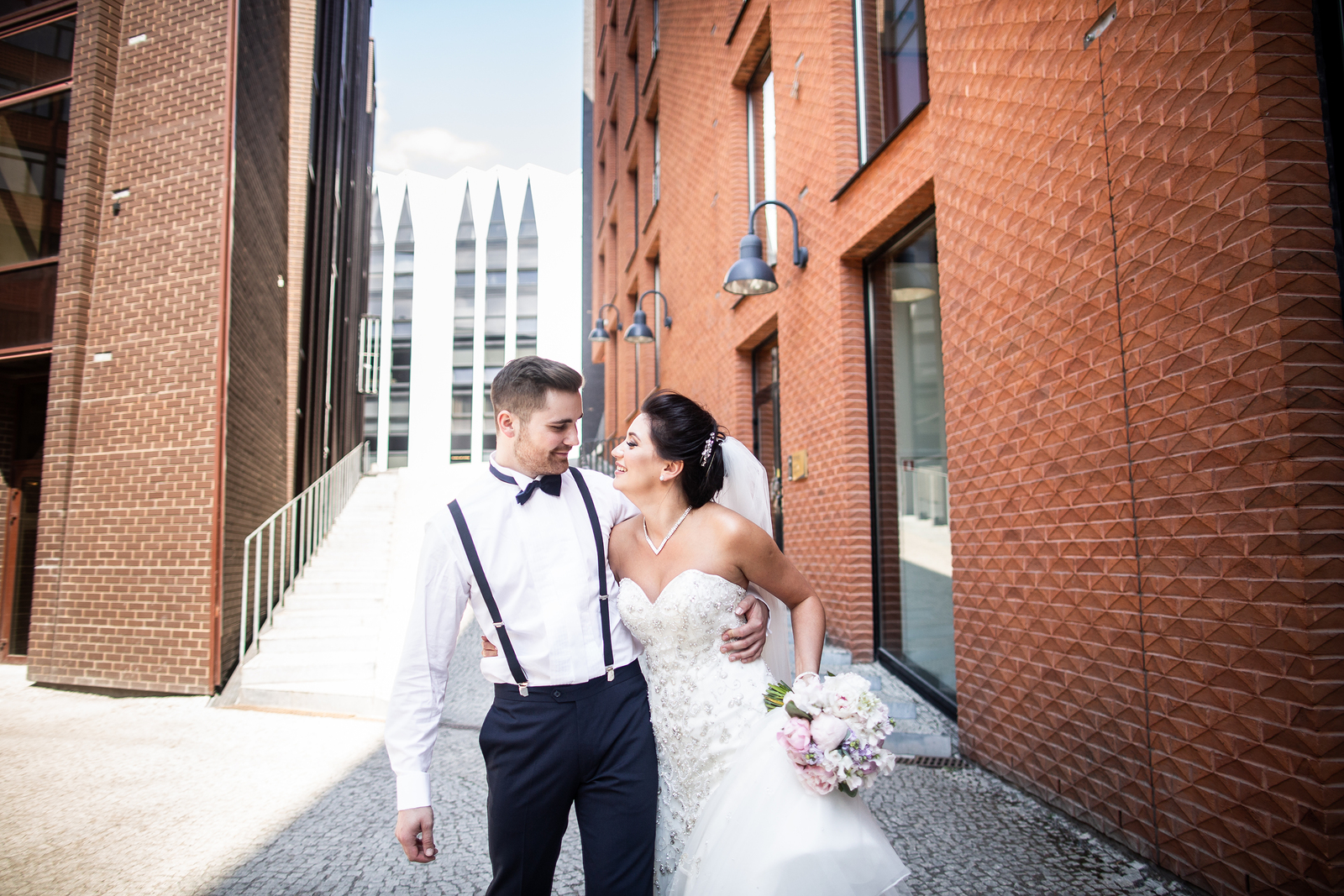 Couple in wedding dress and tuxedo in the middle of a busy city, looking at each other in love and ready to start their life together after premarital therapy in Tigard, OR to prevent relationship problems with a skilled counselor